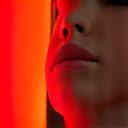 Luz roja terapéutica iluminando suavemente la piel de una persona.